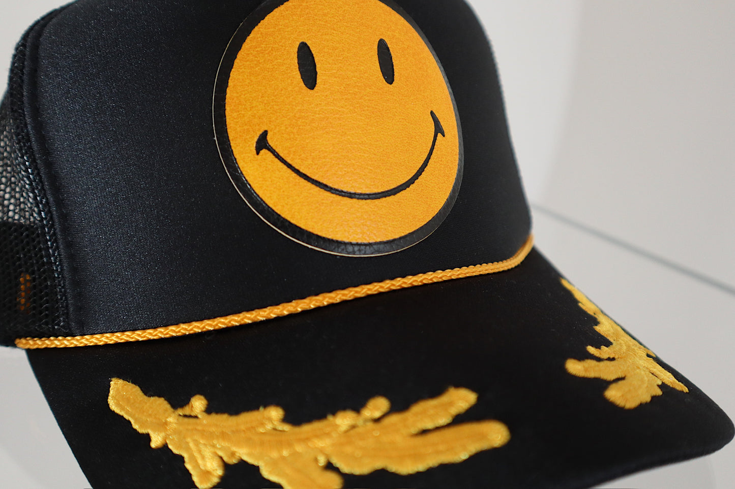 Smiley Yellow Leather On Black and Gold Leaf Trucker Hat